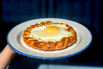 Close up woman holds plate with khachapuri