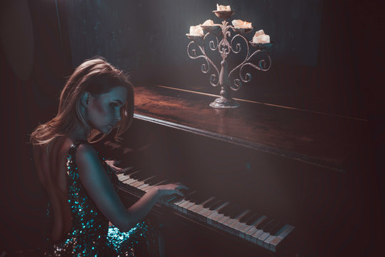 Beautiful woman with fancy elegant dress posing in the piano room