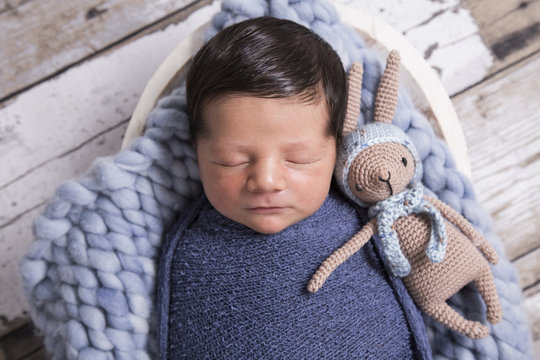 image of a newborn brazilian baby curled sleeping in a blanket