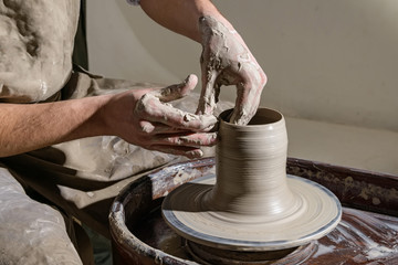 Hands working on pottery wheel