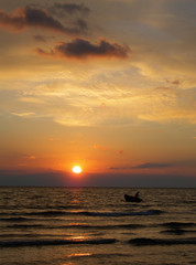 Naklejka na ściany i meble barca sul mare al tramonto,pescatore tra le onde