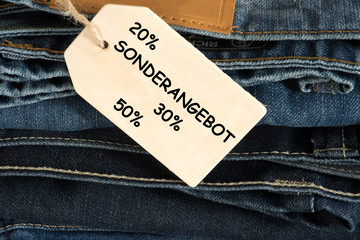 Ein Stapel von Jeans Hosen und ein Schild mit dem Hinweis auf Sonderangebot