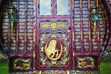 The rear of a traditionally decorated and painted gypsy caravan,  door and windows.