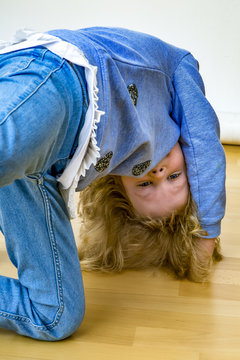 young blond girl is kidding on the floor