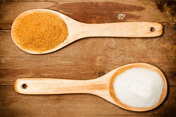 Azúcar morena y blanca con cuchara de madera vista desde arriba