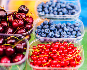 Berry fruits at marketplace  - organic  blueberries, raspberries, strawberries, cherries. Healthy local food market concept..