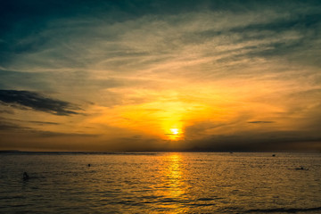 warm orange sunset with people swimming in thailand. ko kut