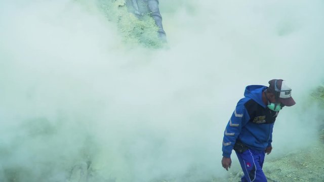 Extraction of sulfur in the crater of a volcano. Sulfur gas, smoke. Kawah Ijen, crater with acidic crater lake where sulfur is mined. Ijen volcano complex is a group of stratovolcanoes in the