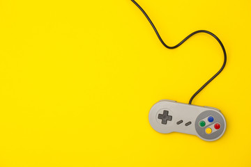 Retro computer gaming controller on a bright yellow background © ink drop