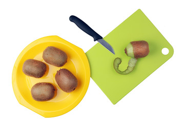 Cleaning the kiwi fruit from the peel in the kitchen isolated.