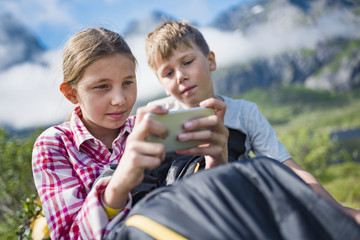 Brother and sister using cell phone
