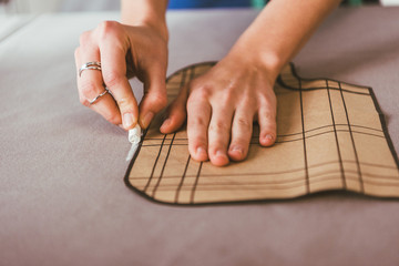 cropped image of dressmaker marking fabric with piece of chalk