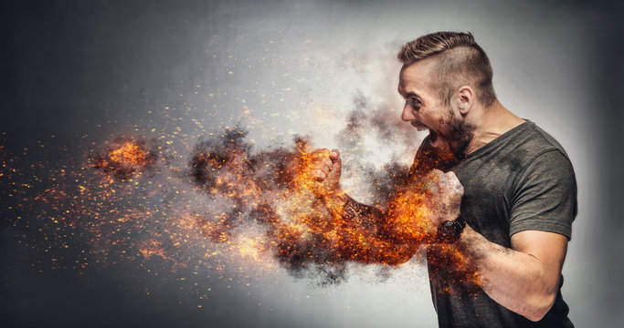 Excited man in fighting gesture with fists on fire.
