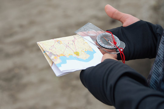 Man holding map.Athlete uses navigation equipment for orienteering,compass and topographic map
