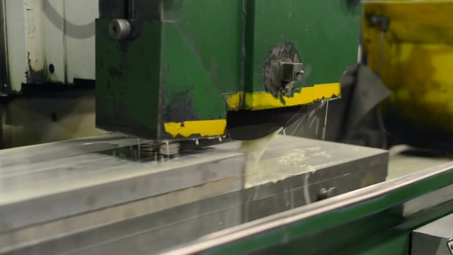 Work of an industrial surface grinding machine. Grinding of a flat metal part.