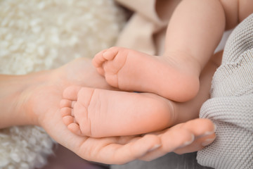 Obraz na płótnie Canvas Mother holding baby feet, closeup