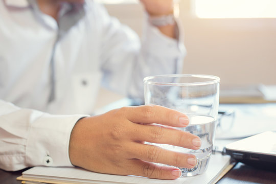 businessman holding glass of drinking water.