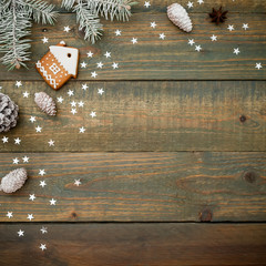 Christmas or New Year composition with pine cones, gingerbread and fir on wooden background. Flat lay, top view.
