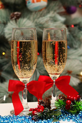 Two glasses with champagne on the background of Christmas decorations