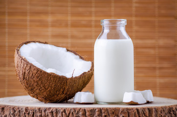 coconut milk in glass bottle on natural brown background