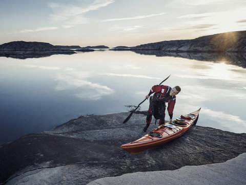 Man with kayak on rock
