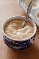 Close up of bowl filled with vanilla, cinnamon egg custard for baking Pasteis de Nata or Pastel de Belem, a traditional Portuguese egg custard pastry dish