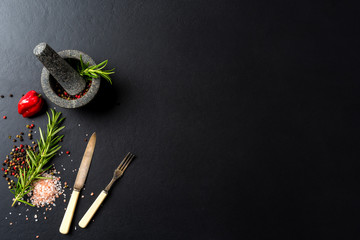 Food background with fresh herbs,  spices and stone mortar