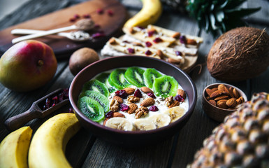 Yogurt with different fruits on a wooden background. Useful food, diet, organic.