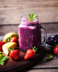 Blueberry smoothies on a wooden background with fruits. Vitamins