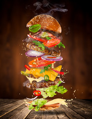 Big tasty burger with flying ingredients.