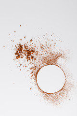 Circle of cocoa powder on white table