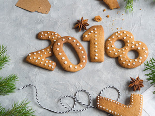 Ginger biscuits of the form of numbers and 2018 new year ginger cookies on grey background. Top view. Seasonal packaging and New Year's attributes
