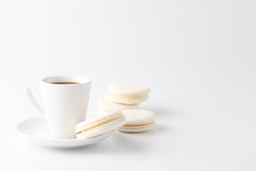 Minimalistic shot of espresso cup with one white macaroon