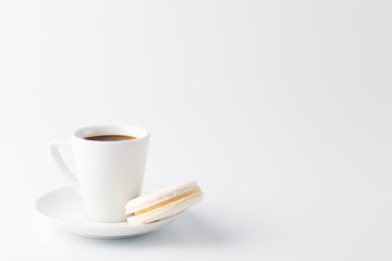 Minimalistic shot of espresso cup with one white macaroon