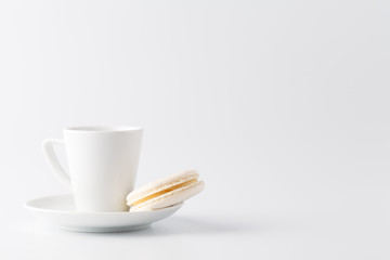 Minimalistic shot of espresso cup with one white macaroon