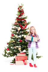 Portrait of little girl standing near Christmas tree with gift box in her hands on white background