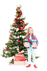 Portrait of little girl standing near Christmas tree with gift box in her hands on white background