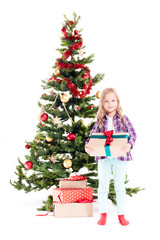 Portrait of little girl standing near Christmas tree with gift box in her hands on white background