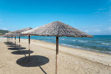 Sarty, Greece, Summer beach without people, sea and sand, empty sea and beach background with straw umbrellas