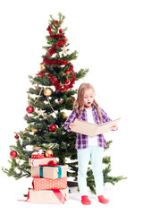 Portrait of cute little girl reading book near Christmas tree on white background