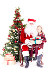 Fototapeta na wymiar Cute little girl receiving gift from Santa Claus sitting on his lap near Christmas tree