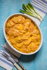 potato gratin with cream and Parmesan cheese on a blue background