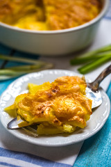 potato gratin with cream and Parmesan cheese on a blue background