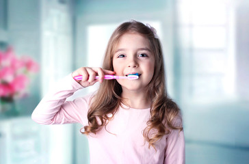 Caucasian child girl cleaning teeth in bathroom.