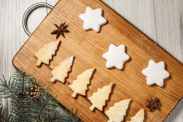 Gingerbread cookies in Christmas tree and star shape on wooden board