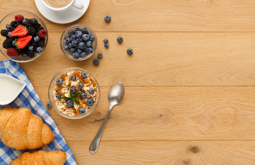 Continental breakfast with croissants and berries on natural wood