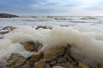 Seafoam on the coast and storm sea 