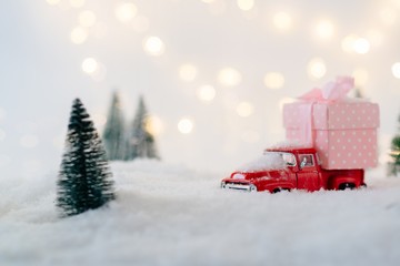 Red toy car carrying Christmas gift.