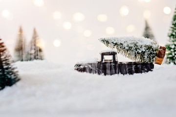 Black toy car carrying Christmas tree.
