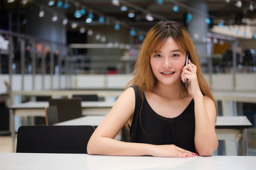 Beautiful young adult thai chinese bronze hair calling smart phone